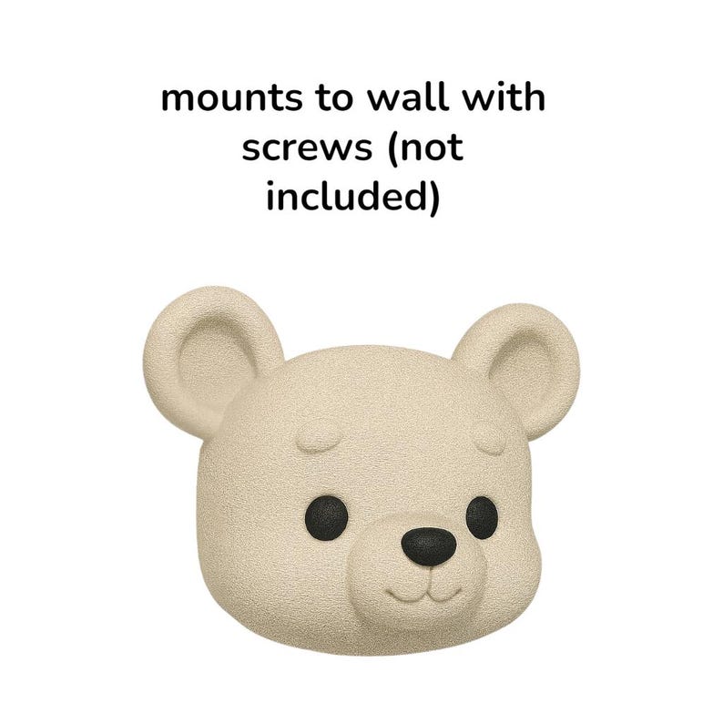 May include: A beige bear-shaped wall mount with black eyes and nose. The text above the bear reads "mounts to wall with screws (not included)". The bear has a textured surface and rounded ears.