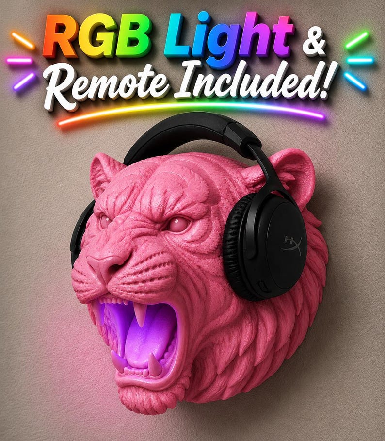 May include: A pink, sculpted tiger head with an open mouth and black headphones. The tiger's mouth glows with purple light. The text "RGB Light & Remote Included!" is displayed above the tiger's head in colorful letters.