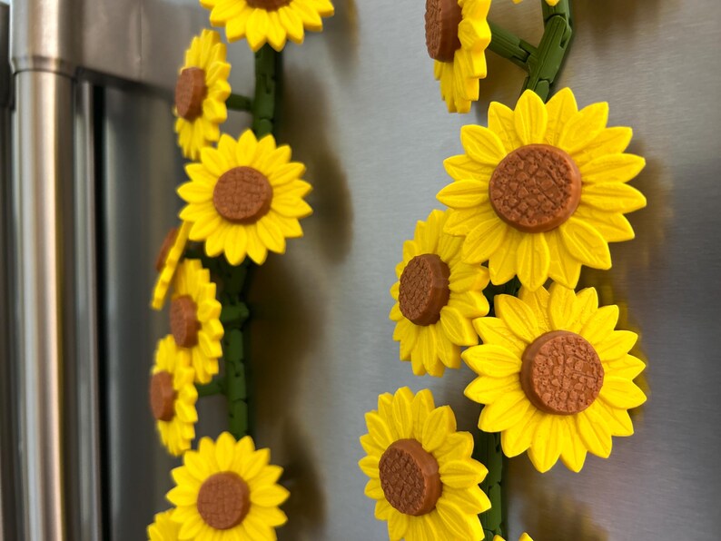 May include: Yellow sunflower magnets with brown centers and green stems. The magnets are arranged in a vertical pattern, creating a cheerful and decorative accent. These magnets are ideal for adding a touch of nature to any metal surface.