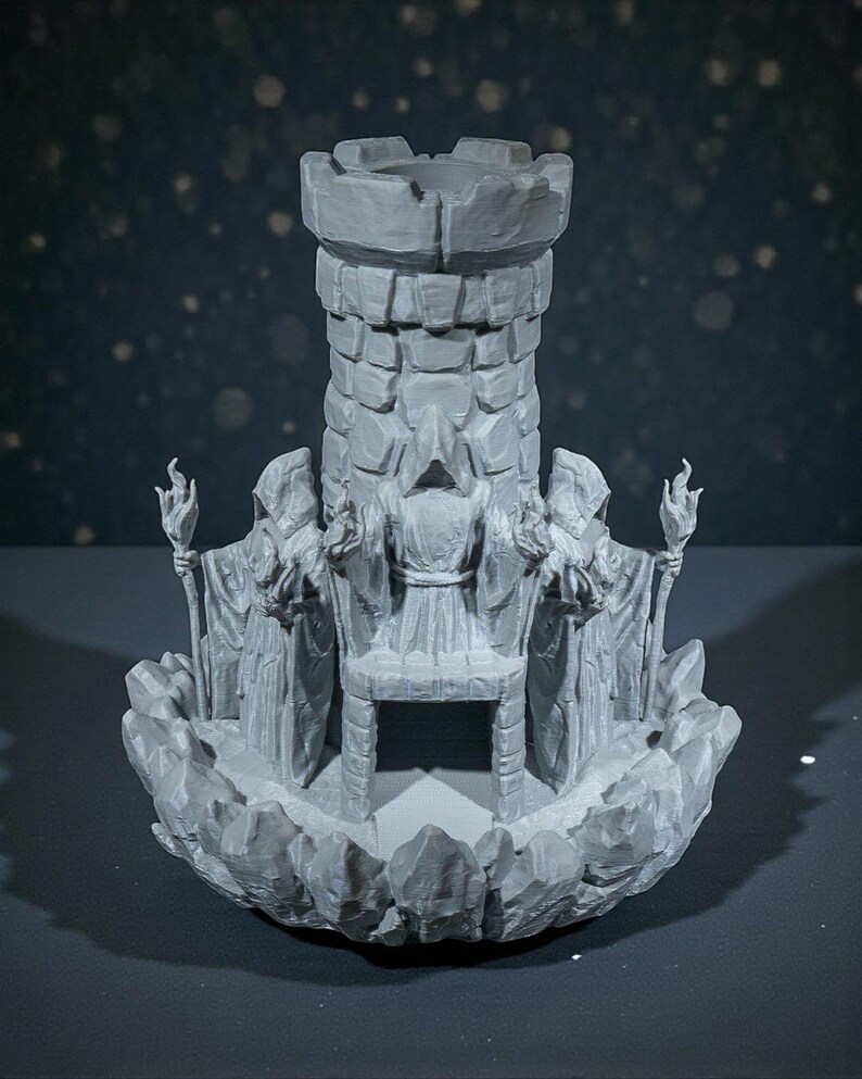 K&ouml;nnte beinhalten: Ein grauer, 3D-gedruckter Fantasy-Burgturm mit gezackter Spitze, umgeben von gewandeten Figuren, die Fackeln halten. Der Sockel hat eine felsige Textur, und der Turm besteht aus steinartigen Bl&ouml;cken. Das Design deutet auf ein mittelalterliches oder Fantasy-Thema hin.