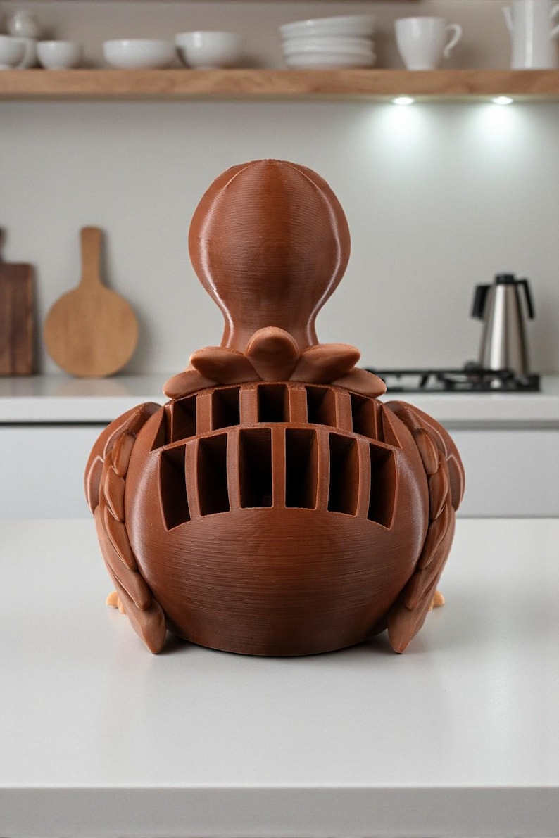 Puede incluir: Un bloque de cuchillos decorativo marr&oacute;n con forma de p&aacute;jaro. El bloque de cuchillos tiene m&uacute;ltiples ranuras para guardar cuchillos y est&aacute; hecho de un material s&oacute;lido y texturizado. Un accesorio de cocina &uacute;nico y funcional.