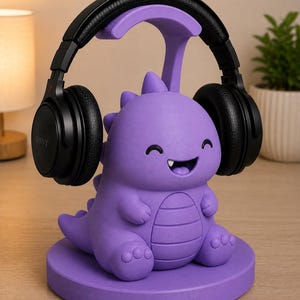 May include: A purple dinosaur-shaped headphone stand with a smiling face, holding a pair of black headphones. The stand is made of a solid material and sits on a round base. The headphones are black with the brand name "SONY" visible.