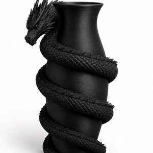 May include: A black vase with a dragon wrapped around it. The dragon's head is at the top, and its body coils down the vase. The vase has a textured surface, and the dragon is intricately detailed.