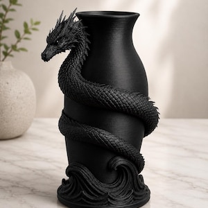 May include: Black vase with a dragon wrapped around the body. The dragon has detailed scales and a fierce expression. The base of the vase features a wave design. The vase is a decorative home decor item.