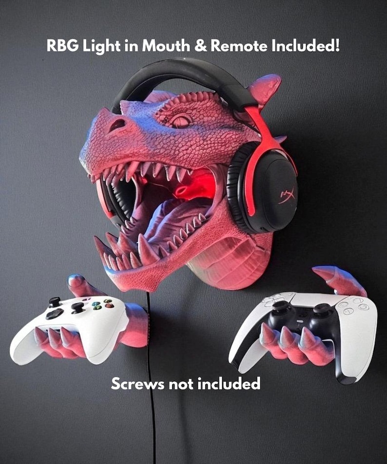 May include: A red and pink dragon head wall mount with a headset and two game controller holders. The dragon's mouth has an RGB light. Text on the image reads: "RBG Light in Mouth & Remote Included!" and "Screws not included."