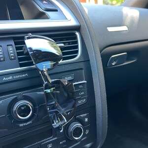 May include: A close-up of a car's dashboard with a pair of sunglasses clipped to the air vent. The dashboard features buttons labeled "Audi concert", "Scan", "Tel", "Car", and "Setup".