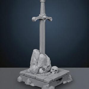 May include: A gray sword in stone sculpture. The sword is upright, with a detailed hilt and crossguard. The stone base features a skull and rock formations, creating a fantasy theme. The sculpture is made of a solid, gray material.