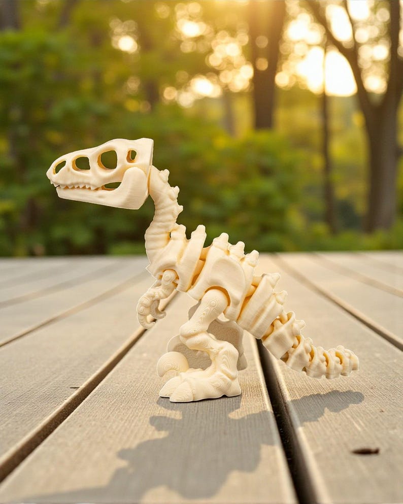 May include: A cream-colored dinosaur skeleton toy, featuring a detailed skull, spine, and limbs. The toy is posed on a wooden surface, with a blurred green background. The dinosaur is a model of a raptor.