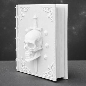 Peut inclure: Un livre blanc imprim&eacute; en 3D avec un cr&acirc;ne transperc&eacute; par une &eacute;p&eacute;e sur la couverture. La couverture pr&eacute;sente des motifs d&eacute;coratifs d'angle et des formes g&eacute;om&eacute;triques. Le livre est l&eacute;g&egrave;rement ouvert, r&eacute;v&eacute;lant les pages.