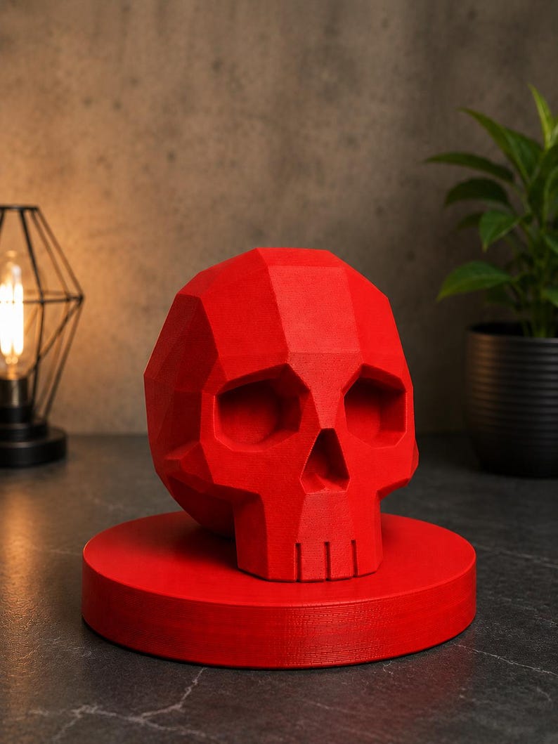 May include: A vibrant red, geometric skull sculpture, resting on a matching circular base. The skull features a faceted design, creating a modern, artistic aesthetic. This decorative piece is ideal for adding a unique touch to home decor.