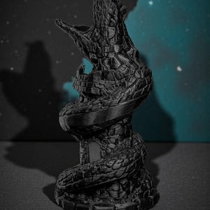 May include: A black, 3D-printed sculpture of a tower entwined by a serpent. The serpent's head is open, as if roaring. The tower has a small door and is textured to resemble stone. The background is a dark blue with a few white dots.