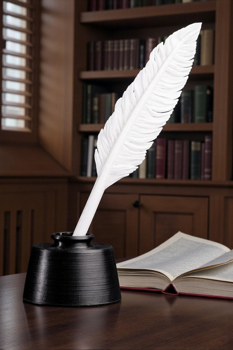 May include: A white feather quill pen in a black inkwell, set on a wooden desk. The quill is prominently displayed, with a detailed feather design. An open book and a bookshelf filled with books are in the background.