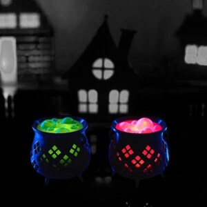 May include: Two black cauldrons with glowing green and red liquid inside. The cauldrons have a decorative design and are lit from within.