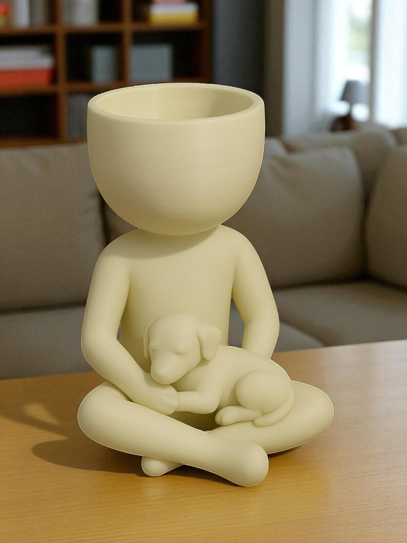 May include: A cream-colored decorative planter shaped like a person seated with legs crossed, cradling a sleeping puppy. The planter has a large, open head for planting. The figurine is made of a smooth material and sits on a wooden surface.
