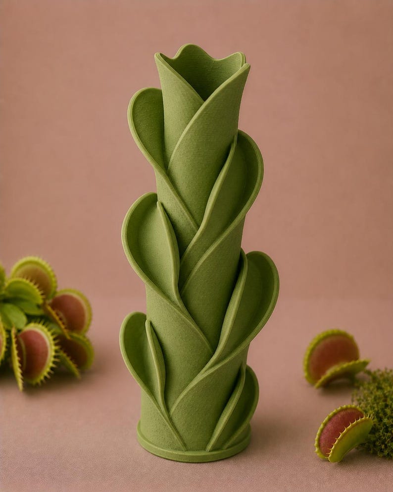 May include: A green, cylindrical vase with a layered, leaf-like design. The vase is a light green color and has a textured surface. Several Venus flytraps are scattered around the vase, with green leaves and red interiors.