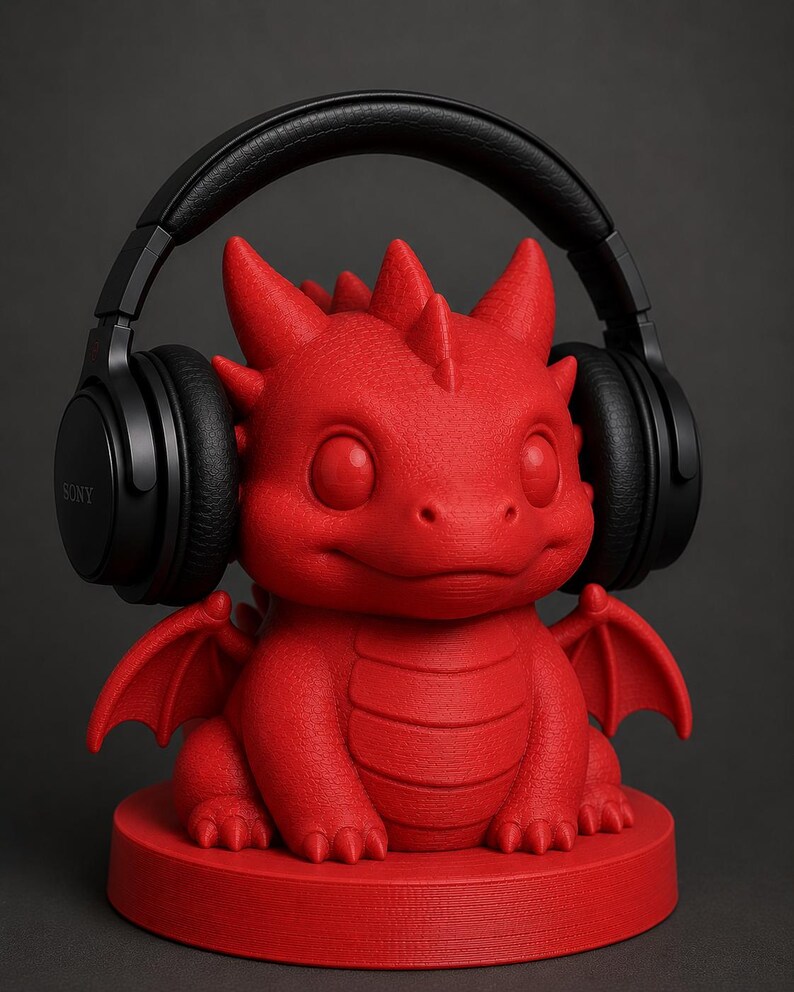 K&ouml;nnte beinhalten: Ein roter Drachen-Kopfh&ouml;rerst&auml;nder mit schwarzen Kopfh&ouml;rern. Der Drache hat gro&szlig;e Augen, kleine Fl&uuml;gel und eine strukturierte Oberfl&auml;che. Auf dem Kopfh&ouml;rer ist der Markenname "SONY" zu sehen.