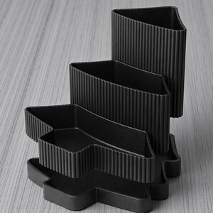 Peut inclure: Une tasse en c&eacute;ramique blanche avec une anse noire et le texte "But First, Coffee" en gras noir. La tasse est pos&eacute;e sur un fond flou, sugg&eacute;rant un cadre chaleureux.