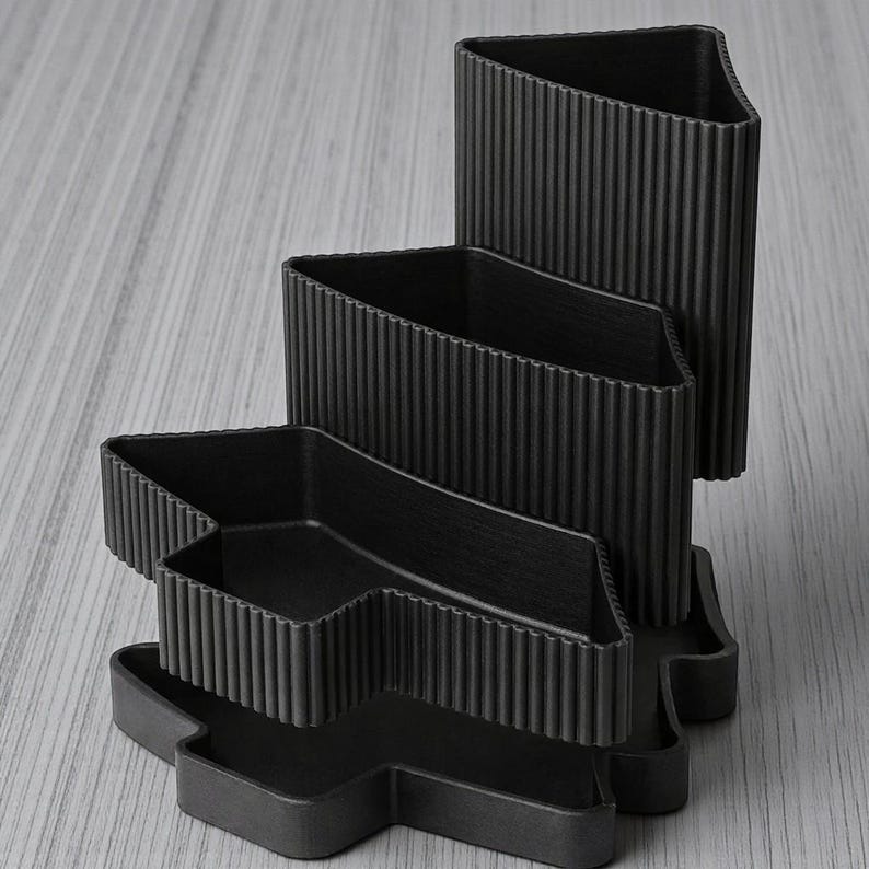 Peut inclure: Une tasse en c&eacute;ramique blanche avec une anse noire et le texte "But First, Coffee" en gras noir. La tasse est pos&eacute;e sur un fond flou, sugg&eacute;rant un cadre chaleureux.