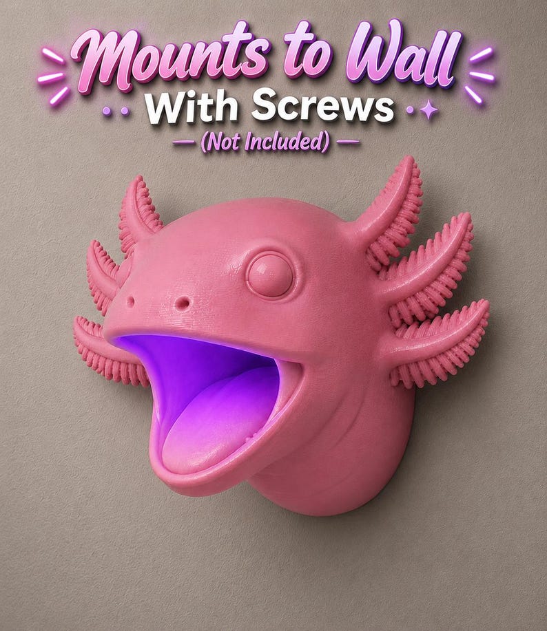 May include: A pink axolotl-shaped wall mount with an open mouth and a purple glow inside. The text "Mounts to Wall With Screws (Not Included)" is above the axolotl. The axolotl has detailed gills and a smooth finish.