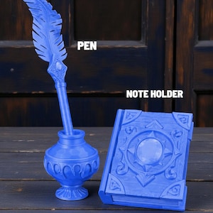 May include: A blue quill pen and inkwell set with the word "PEN" above the pen. A blue note holder is next to the inkwell with the words "NOTE HOLDER" above it. The pen has a feather design. The note holder has a circular design.