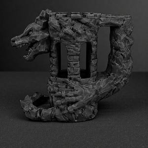 May include: A dark gray, fantasy-themed sculpture of a dragon-shaped castle. The castle features a dragon's head, a tower with arched windows, and a textured, stone-like appearance. The sculpture is designed for tabletop gaming.