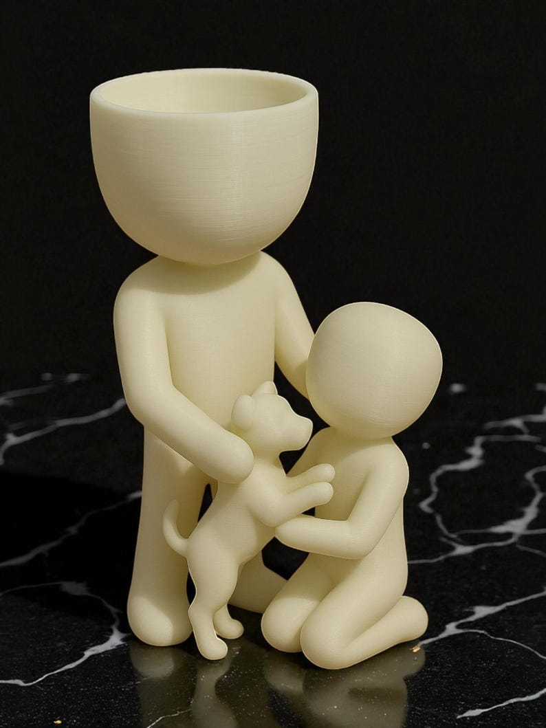 May include: A cream-colored figurine depicting a family with a dog. The tallest figure holds the dog, while a smaller figure kneels, embracing the dog. The figures have rounded heads and simple bodies, creating a minimalist aesthetic.