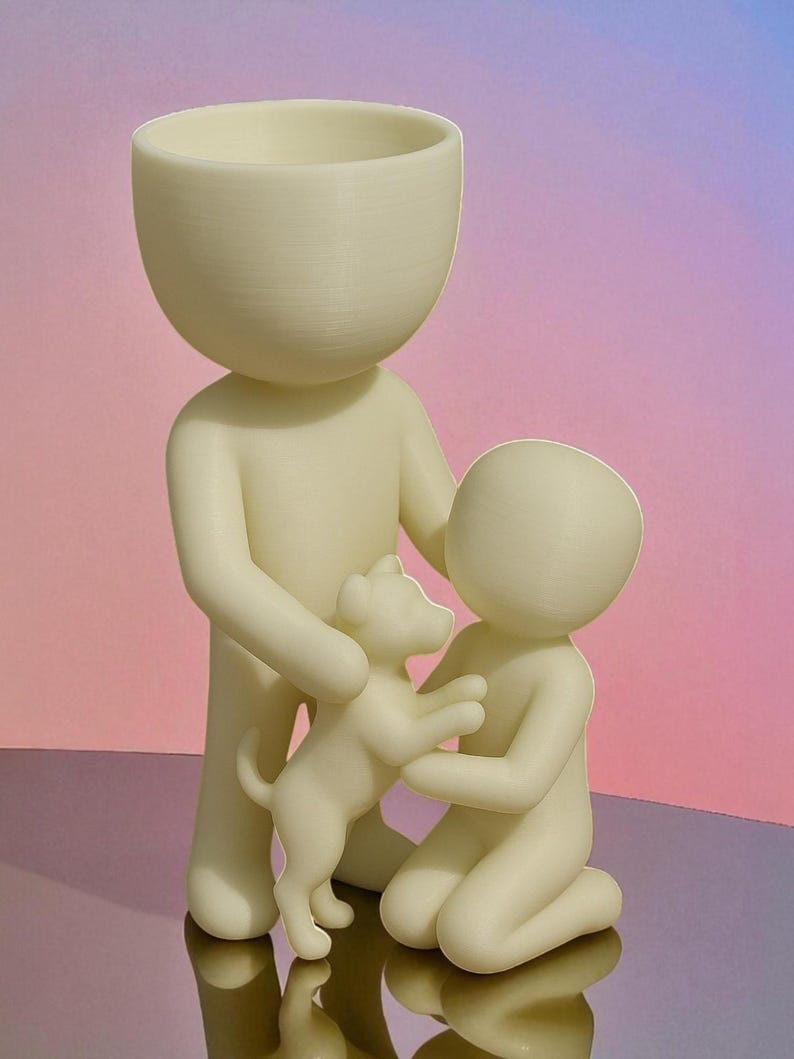 May include: A cream-colored figurine depicts a family with a dog. The adult figure holds the dog, while a child kneels to interact with it. The figures have rounded heads and smooth bodies. The background is a gradient of pink and purple.