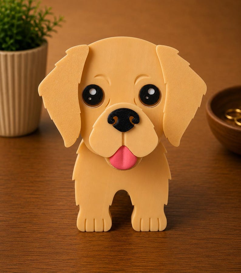 May include: A golden retriever puppy figurine with large black eyes, a black nose, and a pink tongue. The dog has floppy ears and is standing upright. The figurine is made of a light tan material and is on a wooden surface.