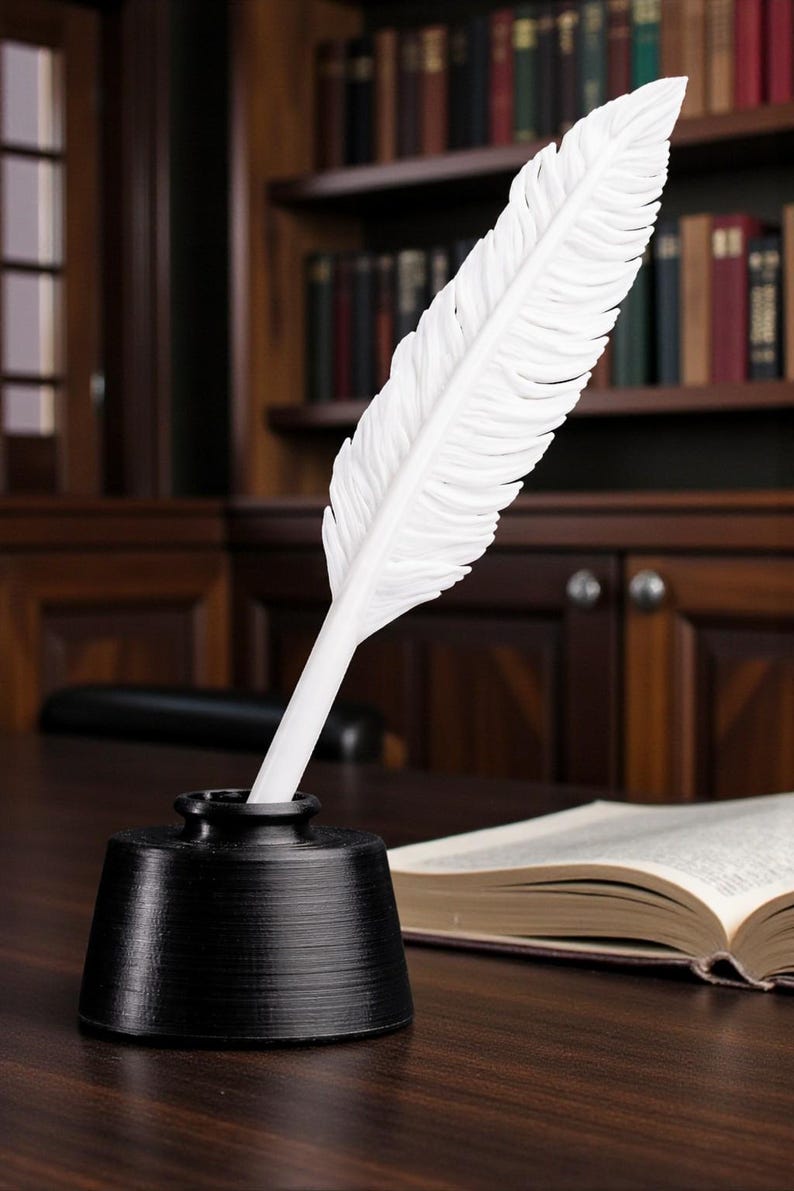 May include: A white feather quill pen is placed in a black inkwell on a dark wooden desk. An open book is visible in the background, with a wooden bookshelf filled with books. The scene evokes a classic writing or study setting.