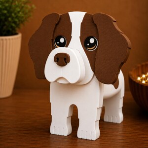May include: A wooden dog figurine with a white body and brown ears and patches. The dog has large, expressive eyes and a white snout. The figurine is standing on a wooden surface.