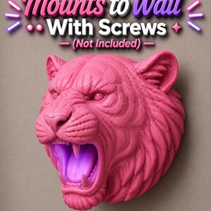 May include: A pink tiger head wall mount with an open mouth and visible teeth. The text "Mounts to Wall With Screws - (Not Included)" is above the tiger head. The tiger head is a decorative item.