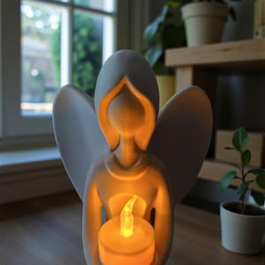 May include: A white angel figurine holding a glowing LED candle. The angel has outstretched wings and a serene expression. The candle emits a warm, inviting light, creating a peaceful ambiance. The figurine is on a wooden surface.