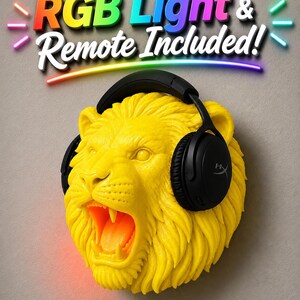 Puede incluir: Escultura de cabeza de le&oacute;n amarilla con auriculares negros. La escultura tiene la boca abierta y una luz RGB, con mando a distancia incluido. El texto "RGB Light & Remote Included!" est&aacute; encima de la cabeza del le&oacute;n.