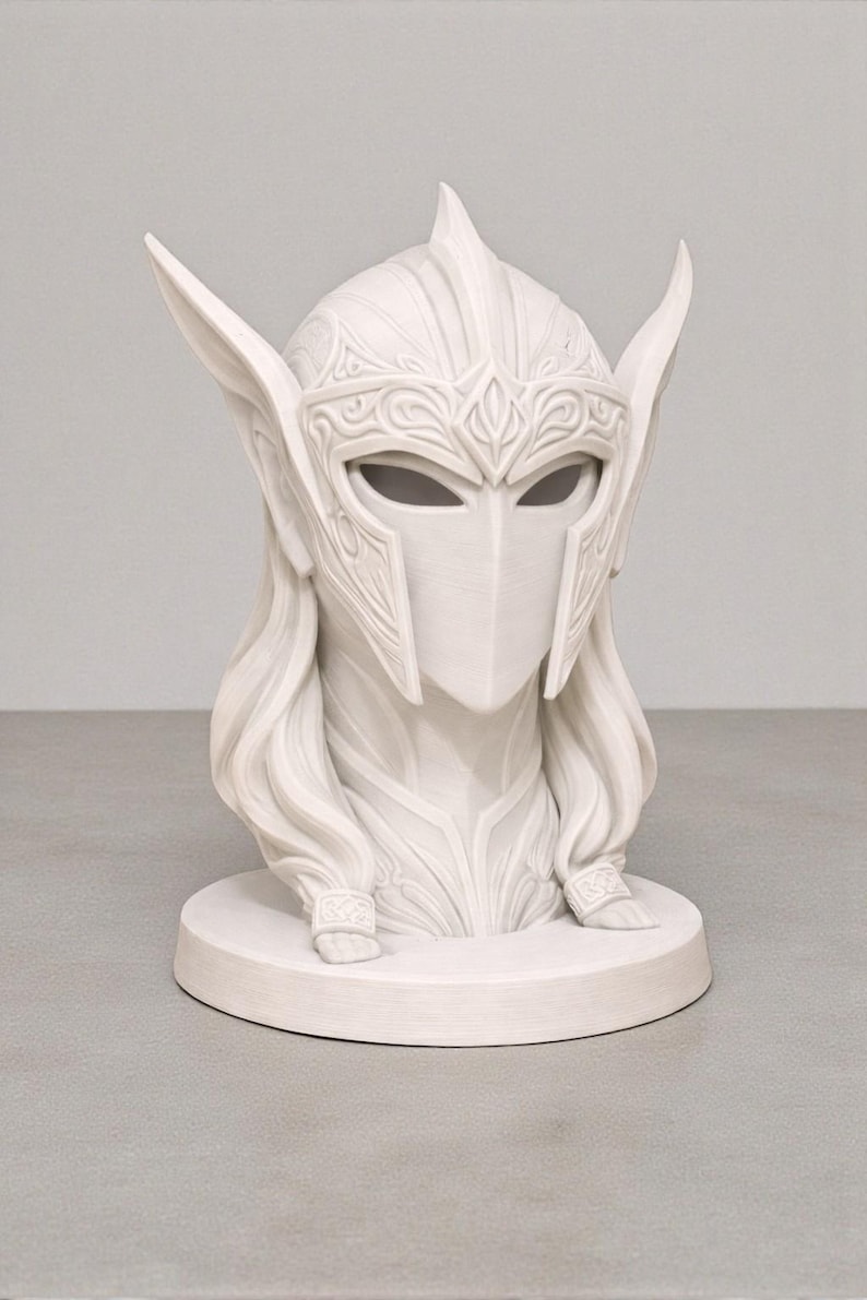 May include: A white bust depicting a helmeted figure with long hair. The helmet has detailed patterns and eye slits. The sculpture sits on a circular base, suggesting a fantasy or historical theme, crafted with intricate detail.