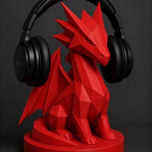 May include: A red, geometric dragon-shaped headphone stand. The stand is holding a pair of black over-ear headphones. The dragon has a detailed, angular design and sits on a circular base. The headphones are branded with the Sony logo.