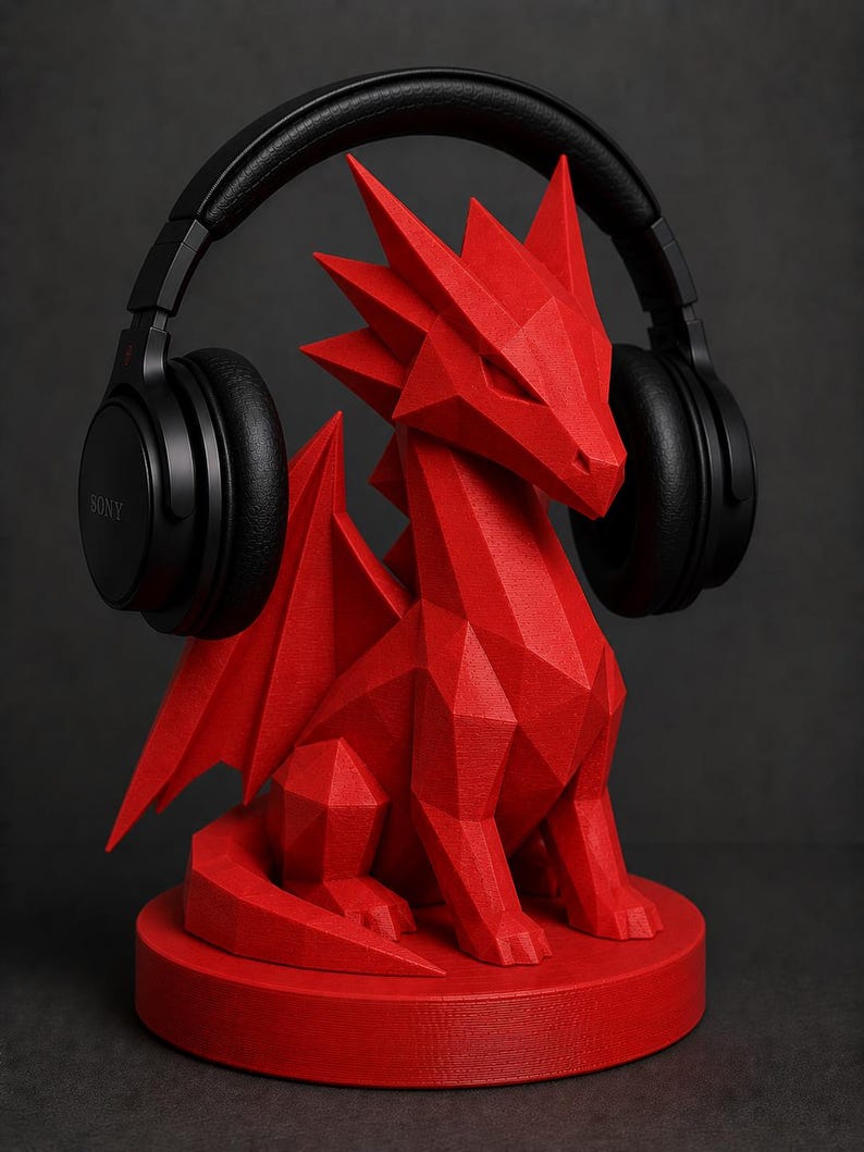 May include: A red, geometric dragon-shaped headphone stand. The stand is holding a pair of black over-ear headphones. The dragon has a detailed, angular design and sits on a circular base. The headphones are branded with the Sony logo.
