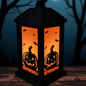 May include: Black Halloween lantern with orange interior, featuring jack-o'-lantern and bat silhouettes. The lantern is set against a backdrop of a moonlit night with silhouetted trees, creating a spooky ambiance. Perfect for Halloween decor.