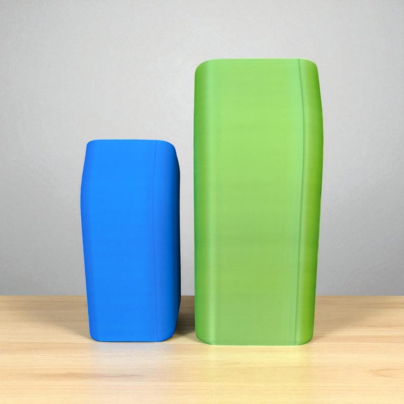 May include: Two rectangular, curved-edge containers. One is bright blue, the other is a vibrant green. Both are standing on a light wood surface against a neutral gray background. The containers have a smooth, matte finish.