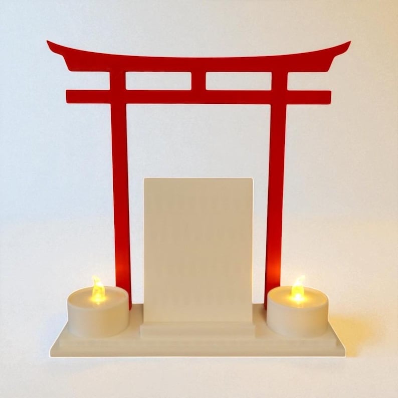 May include: A red Torii gate-shaped display with a white base, a central rectangular panel, and two battery-operated candle lights. The gate is a traditional Japanese architectural structure.