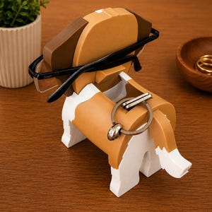 May include: A wooden dog-shaped desk organizer in brown, white, and black. The organizer holds a pair of black-framed glasses and a silver keychain. The dog has a playful design, perfect for holding small items on a desk or nightstand.