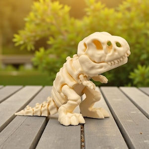 May include: A cream-colored Tyrannosaurus Rex skeleton figurine. The dinosaur model is posed on a wooden surface, showcasing its skeletal structure, including the skull, ribs, and tail. The background features green foliage and sunlight.