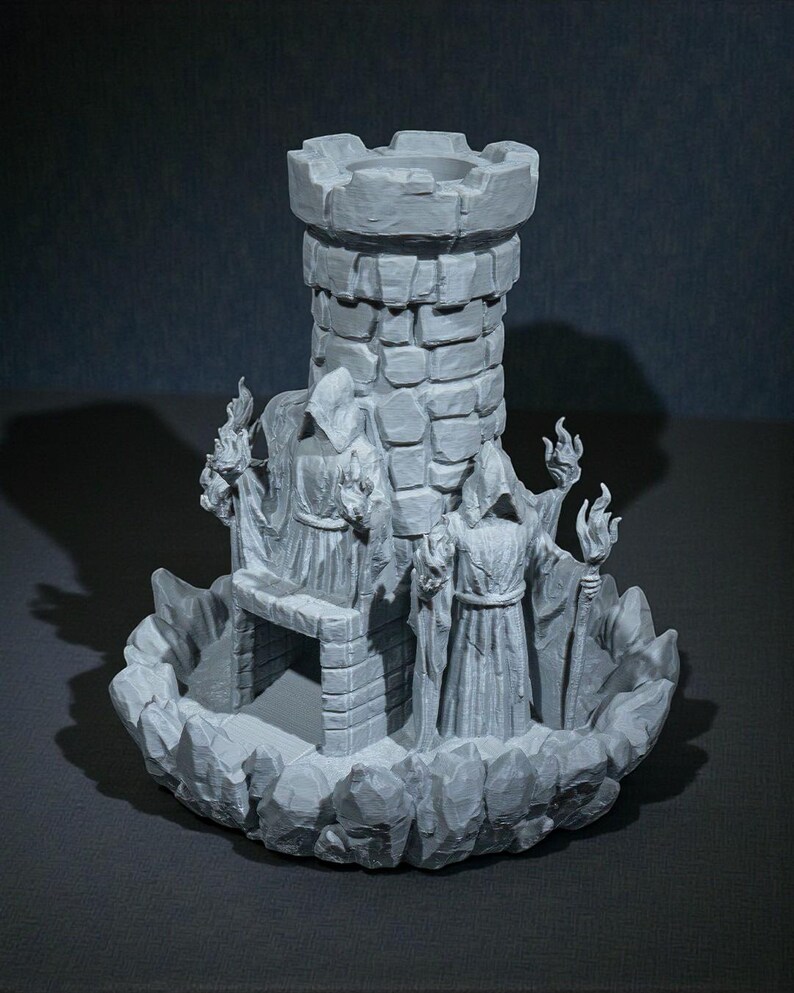 K&ouml;nnte beinhalten: Ein grauer, 3D-gedruckter Fantasy-Burgturm mit zwei Figuren in Roben, die Fackeln halten. Der Turm hat eine zinnenbewehrte Spitze und ist von einem felsigen Sockel umgeben. Die Figuren sind detailliert mit Kapuzenm&auml;nteln und St&auml;ben.