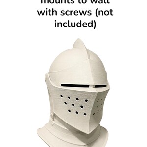 May include: A cream-colored knight's helmet with a textured surface. The helmet has a visor with small holes and a pointed top. Text on the image reads "mounts to wall with screws (not included)".