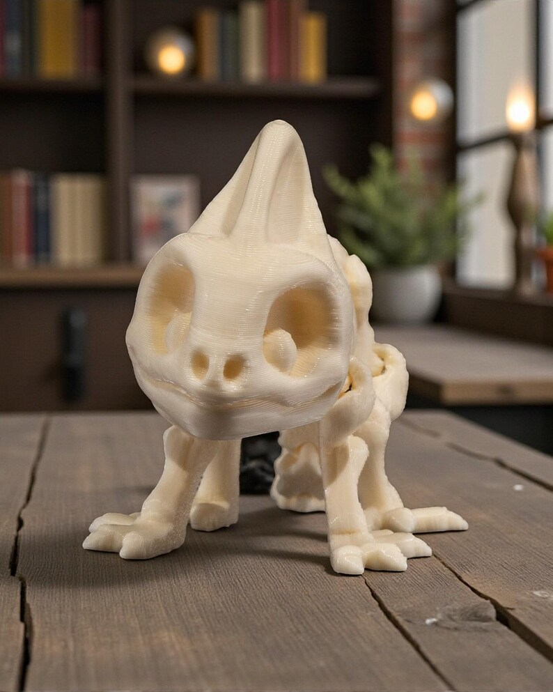 Op de afbeelding: Een cr&egrave;mekleurig, 3D-geprint dinosaurus skeletbeeldje. Het gedetailleerde model heeft een grote kop met oogkassen en een prominente kam, samen met gelede poten en voeten. Het beeldje staat op een houten oppervlak.