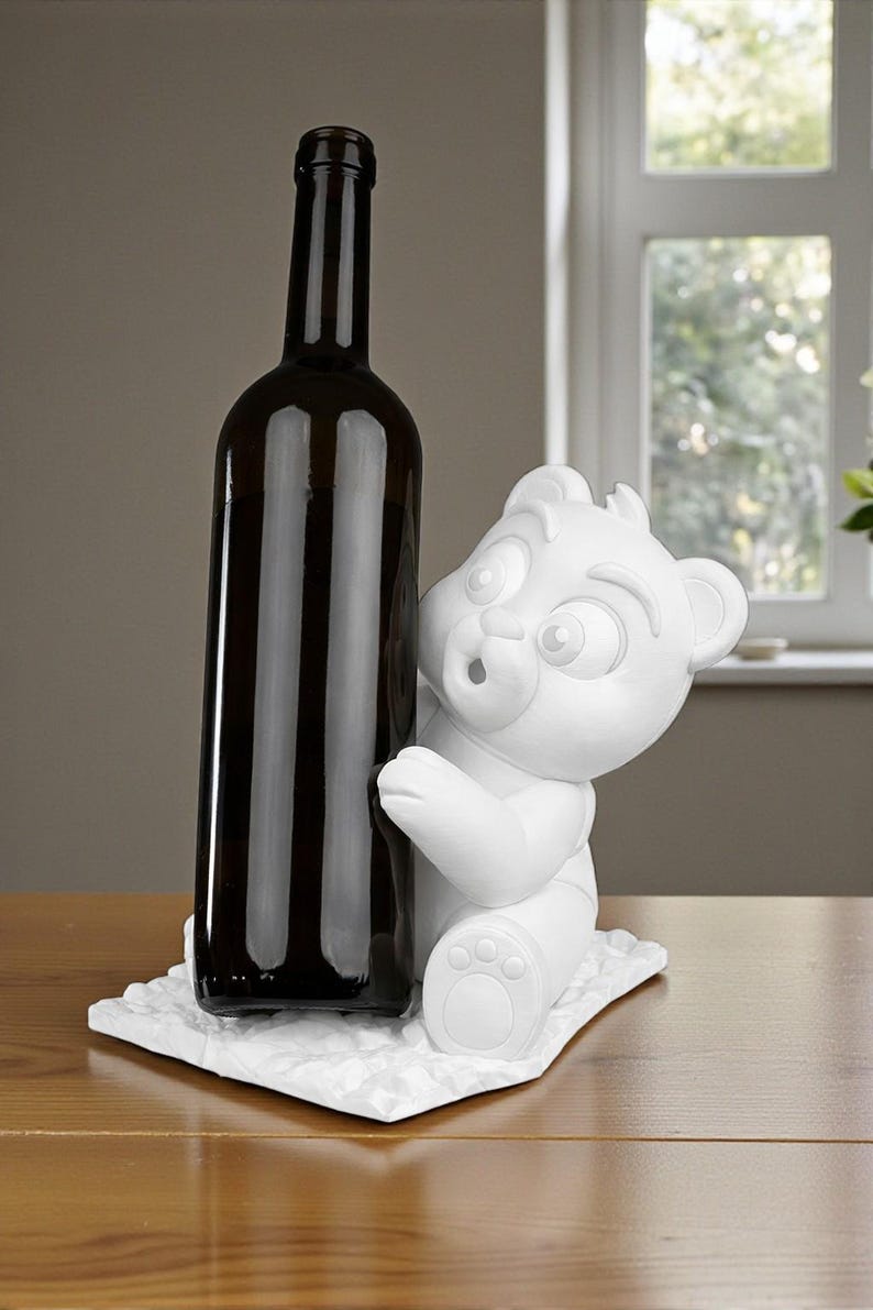 May include: A dark brown wine bottle stands next to a white bear figurine. The bear is sculpted with a surprised expression and is sitting on a textured white base. The bottle is tall and slender.
