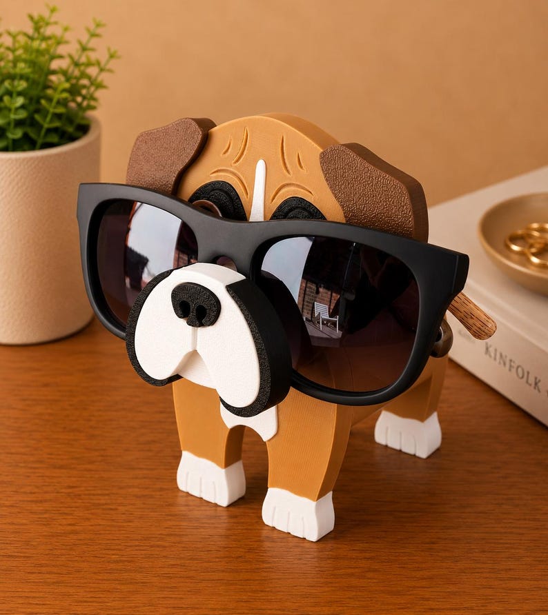 Peut inclure: Un porte-lunettes en forme de chien en bois avec des lunettes de soleil noires. Le support est marron, blanc et noir, avec les lunettes de soleil pos&eacute;es sur le nez du chien. Le chien a des pattes blanches et un visage blanc et noir.