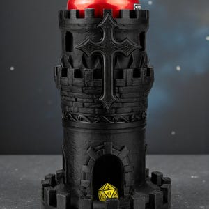 May include: Black, castle-shaped can holder with a cross design. A red can sits inside the holder. A yellow and black die is visible in the base. The holder has a medieval theme.