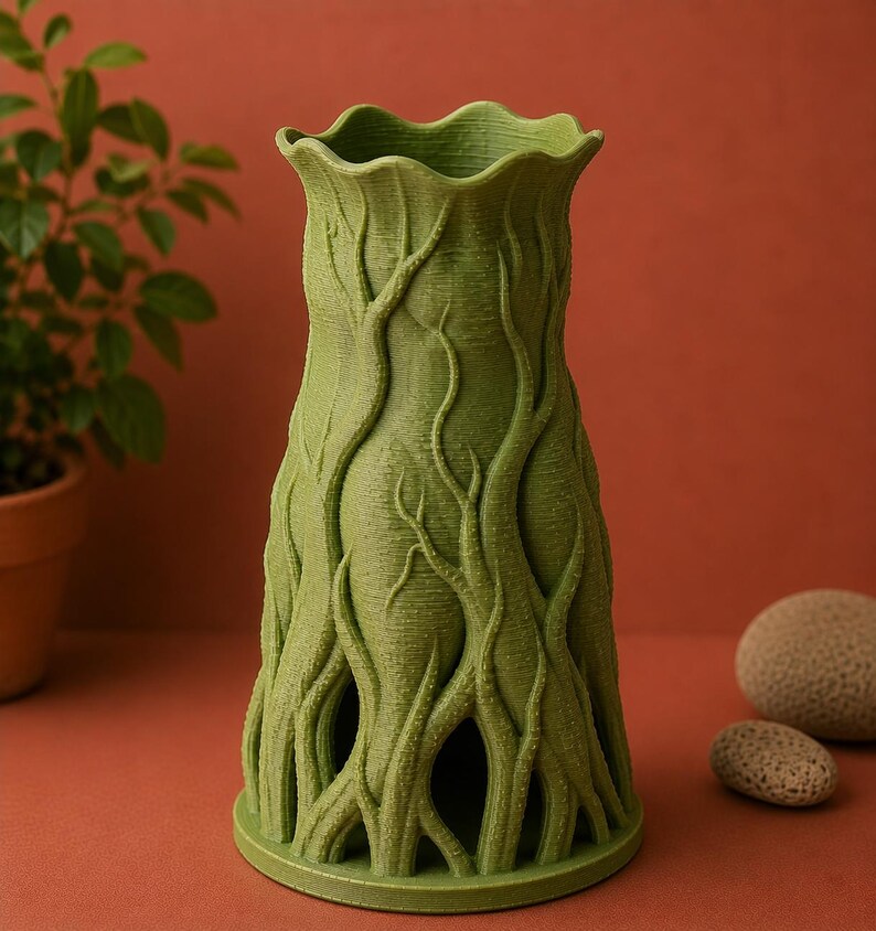 May include: A green, tree-trunk-inspired vase with a textured surface. The vase has a flared top and a round base. The design features intricate, raised patterns resembling tree branches and roots. The vase is approximately 8 inches tall.
