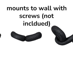 May include: Black snake-shaped wall decor with a textured surface. The image includes the snake's head, two curved segments, and a coiled tail. Text above reads "mounts to wall with screws (not included)".