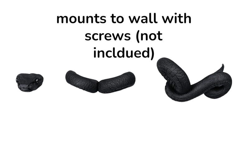 May include: Black snake-shaped wall decor with a textured surface. The image includes the snake's head, two curved segments, and a coiled tail. Text above reads "mounts to wall with screws (not included)".